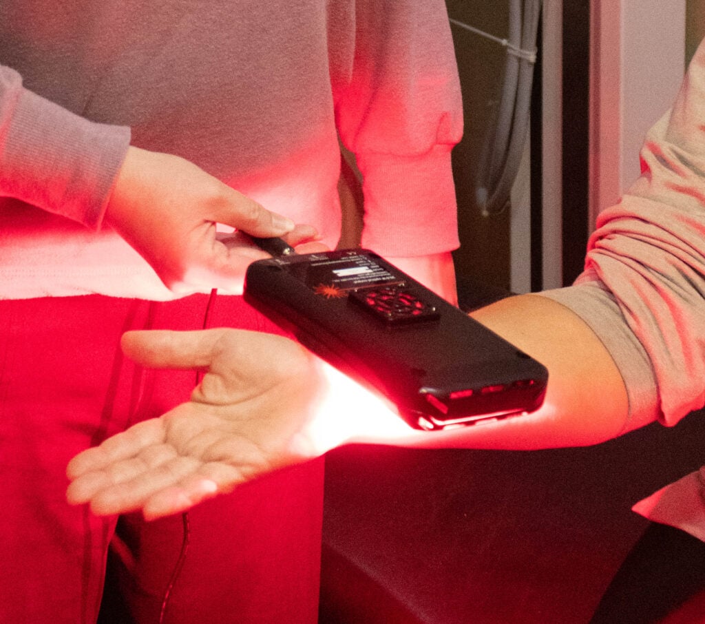 Dr. Kelly applying focused red infrared light therapy to a patient at Tree of Life Wellness Center